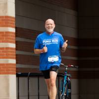Participant nearing finish line holding thumbs up